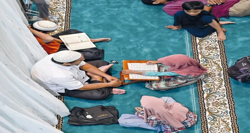 أطفال يتعلمون تلاوة القرآن بعد صلاة الظهر في مسجد المعمور خلال شهر رمضان المبارك في باندا آتشيه بإندونيسيا.